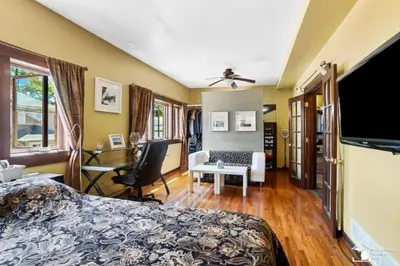 a bedroom with a bed and a desk and a tv at Part of Mini-Mansion, private, 3 story Lake Erie views in Luna Pier
