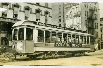 an old trolley car on a city street with buildings at Part of Mini-Mansion, private, 3 story Lake Erie views in Luna Pier