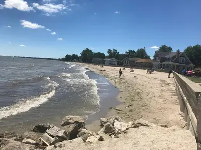 a beach with people on the sand and water at Actual Pretty Boy Floyd's Hideout - Lake Erie, MI in Luna Pier