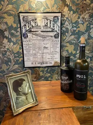 a bottle of whiskey and a picture on a table at Actual Pretty Boy Floyd's Hideout - Lake Erie, MI in Luna Pier