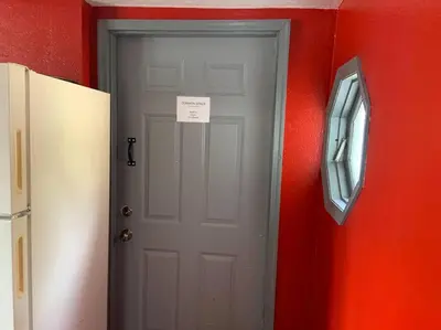 a white door in a red wall with a sign on it at Actual Pretty Boy Floyd's Hideout - Lake Erie, MI in Luna Pier