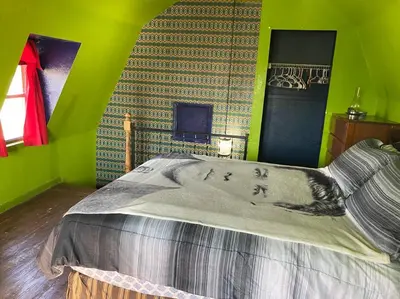 a bedroom with a bed with a green wall at Actual Pretty Boy Floyd's Hideout - Lake Erie, MI in Luna Pier