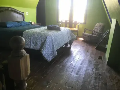 a bedroom with a bed and a chair at Actual Pretty Boy Floyd's Hideout - Lake Erie, MI in Luna Pier