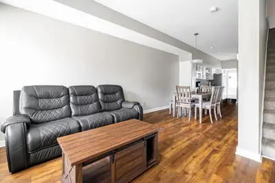 a living room with a black leather couch and a table at Luxury Downtown Townhome Unit 7 in Cleveland