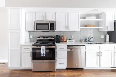 a kitchen with white cabinets and a stove and microwave at Luxury Downtown Townhome Unit 7 in Cleveland