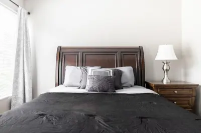 a bedroom with a bed and a lamp and a window at Luxury Downtown Townhome Unit 7 in Cleveland
