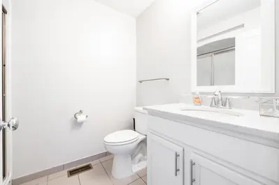 a white bathroom with a toilet and a sink at Luxury Downtown Townhome Unit 7 in Cleveland