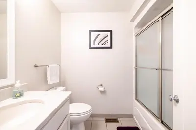 a white bathroom with a toilet and a shower at Luxury Downtown Townhome Unit 15 in Cleveland