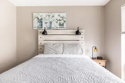 a bedroom with a white bed and a wooden headboard at Luxury Downtown Townhome Unit 15 in Cleveland