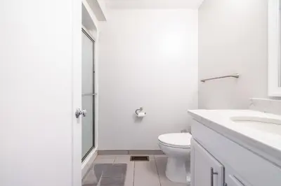 a white bathroom with a toilet and a sink at Luxury Downtown Townhome Unit 5 in Cleveland