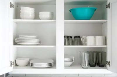 a white cabinet filled with plates and bowls at Luxury Downtown Townhome Unit 5 in Cleveland