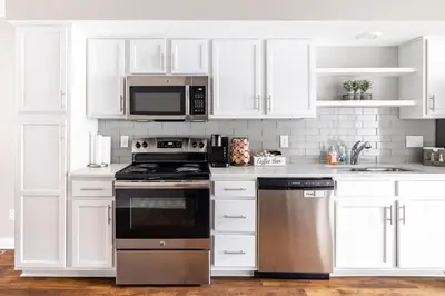 a kitchen with white cabinets and a stove and microwave at Luxury Downtown Townhome Unit 5 in Cleveland