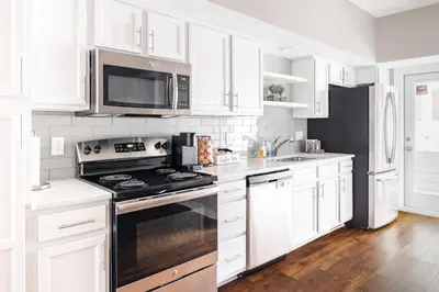 a white kitchen with a stove and a microwave at Luxury Downtown Townhome Unit 5 in Cleveland