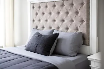 a bed with a white headboard and two pillows at Luxury Downtown Townhome Unit 5 in Cleveland