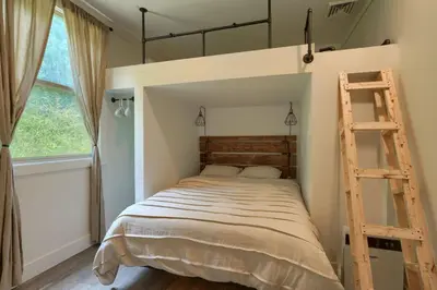 a bedroom with a bunk bed with a ladder at Swaying Pines Cabin w/EV Charger in South Bloomingville