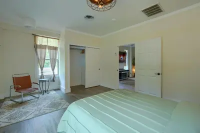 a bedroom with a large bed and a chair at Swaying Pines Cabin w/EV Charger in South Bloomingville
