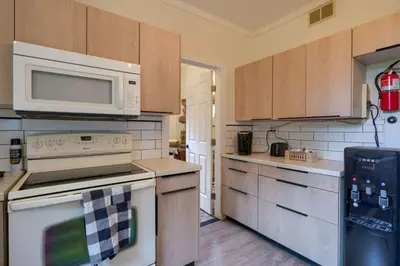 a kitchen with white appliances and wooden cabinets at Swaying Pines Cabin w/EV Charger in South Bloomingville