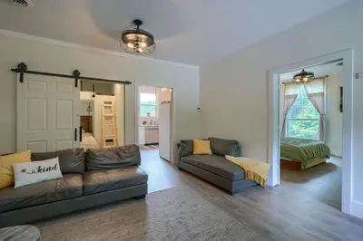 a living room with a couch and a bedroom at Swaying Pines Cabin w/EV Charger in South Bloomingville
