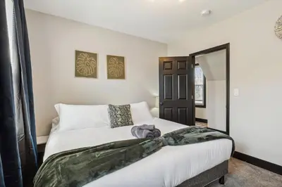 a bedroom with a large bed with white sheets at Fairfax Urban Oasis - New Reno - 5 mins to Clinic in Cleveland