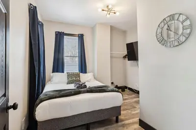 a bedroom with a bed and a clock on the wall at Fairfax Urban Oasis - New Reno - 5 mins to Clinic in Cleveland