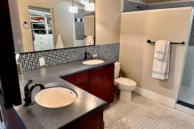 a bathroom with a sink and a toilet and a mirror at Downtown Delight with Patio! 1 Mi to Ball State in Muncie