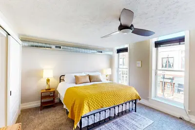 a bedroom with a bed and a ceiling fan at Downtown Delight with Patio! 1 Mi to Ball State in Muncie