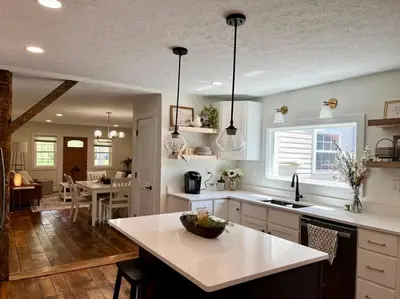 a kitchen with white cabinets and a kitchen island at A Winfield Bungalow in Dover