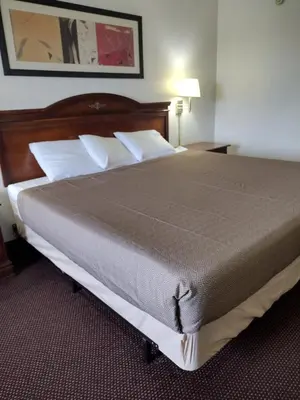 a bedroom with a large bed with white pillows at Hoosier Inn- Portland in Portland