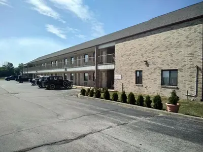 a brick building with cars parked in front of it at Hoosier Inn- Portland in Portland