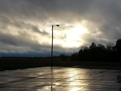 a street light in a parking lot with a cloudy sky at Hoosier Inn- Portland in Portland