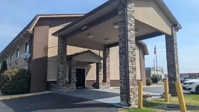 a building with a garage with a parking lot at Super 8 by Wyndham Shelbyville in Shelbyville