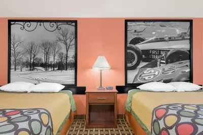 a motel room with two beds and two posters at Super 8 by Wyndham Shelbyville in Shelbyville