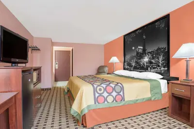 a hotel room with a bed and a flat screen tv at Super 8 by Wyndham Shelbyville in Shelbyville
