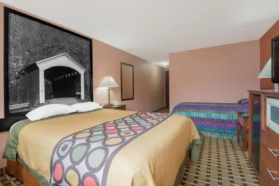 a hotel room with a large bed and a tv at Super 8 by Wyndham Shelbyville in Shelbyville