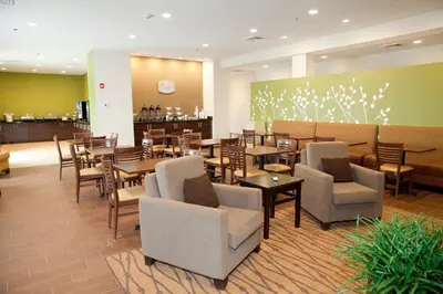 a restaurant with tables and chairs and a bar at Sleep Inn & Suites Belmont - St. Clairsville in Belmont