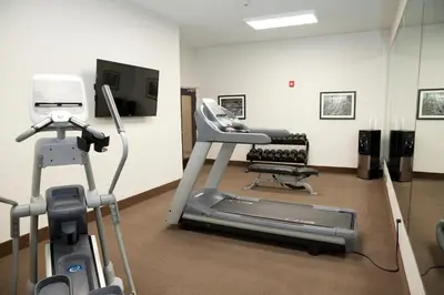 a gym with a treadmill and a chair in a room at Sleep Inn & Suites Belmont - St. Clairsville in Belmont