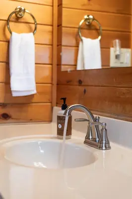 a bathroom sink with a faucet and white towels at Sage Brush Cabin in Millersburg