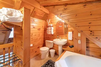 a log cabin bathroom with a toilet and a sink at Sage Brush Cabin in Millersburg