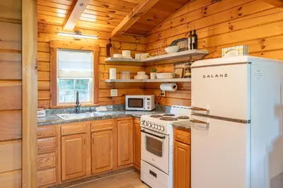 a kitchen with a white refrigerator and a stove at Sage Brush Cabin in Millersburg