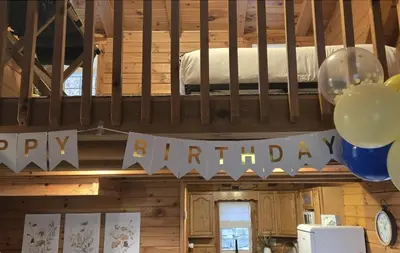 a room with a birthday sign and balloons at Sage Brush Cabin in Millersburg