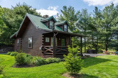 a log cabin with a green roof at Sage Brush Cabin in Millersburg