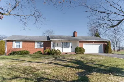 a red brick house with a white garage at Sunset Cottage in Good Hope