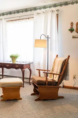 a living room with a rocking chair and a piano at Sunset Cottage in Good Hope