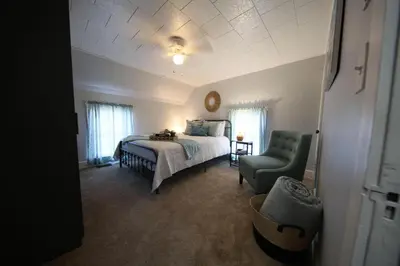 a bedroom with a bed and a green chair at Wayfarer Inn in Dalton