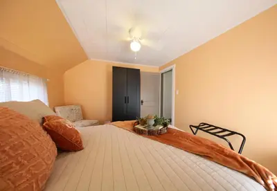 a bedroom with a large bed and a chair at Wayfarer Inn in Dalton