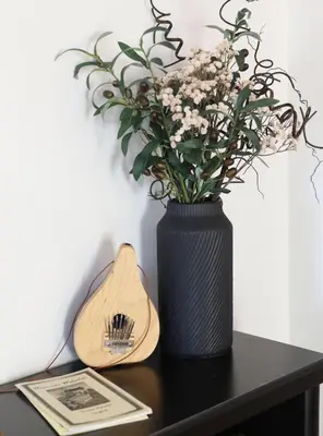 a black vase with flowers sitting on a table at Wayfarer Inn in Dalton