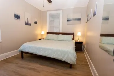 a bedroom with a bed with white sheets and two lamps at Rolston 1 Bedroom House near Xavier, Downtown in Bellevue