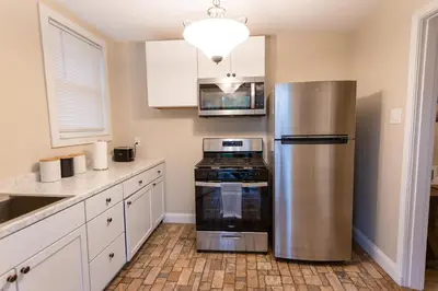 a kitchen with a stainless steel refrigerator and a stove at Rolston 1 Bedroom House near Xavier, Downtown in Bellevue