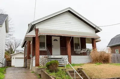 a brick house with a white door and a porch at Rolston 1 Bedroom House near Xavier, Downtown in Bellevue