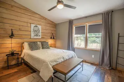 a bedroom with a bed and a ceiling fan at Nature's Nest - Woodsy Retreat w/ Renovated Deck & Hot Tub in Logan